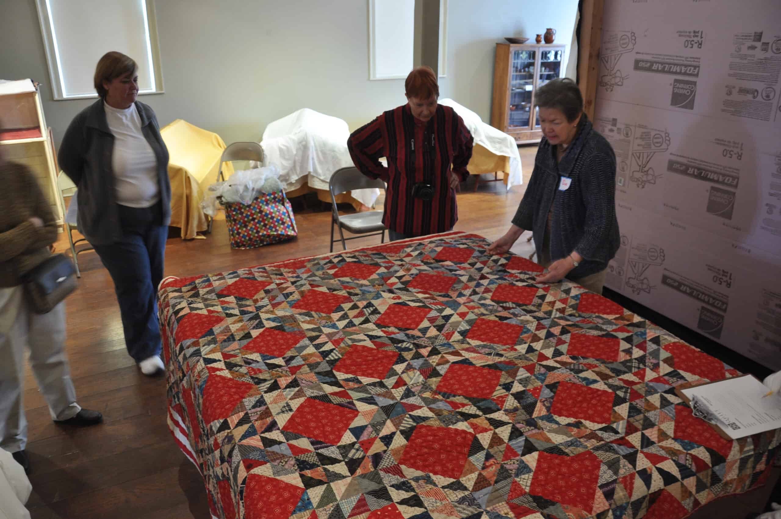 Quilt historian and lecturer Sue Reich from Washington Depot examines a quilt brought to the Norwalk Historical Society during Quilt Discovery Day in April 2011.